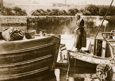 A woman securing the stern of her barge, London by English Photographer